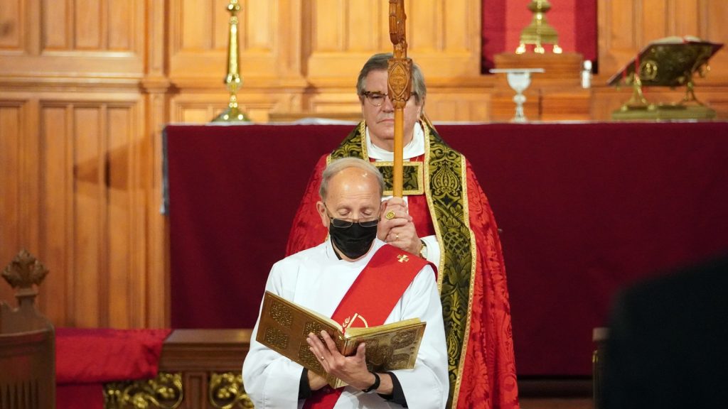 deacon reading from Gospel book